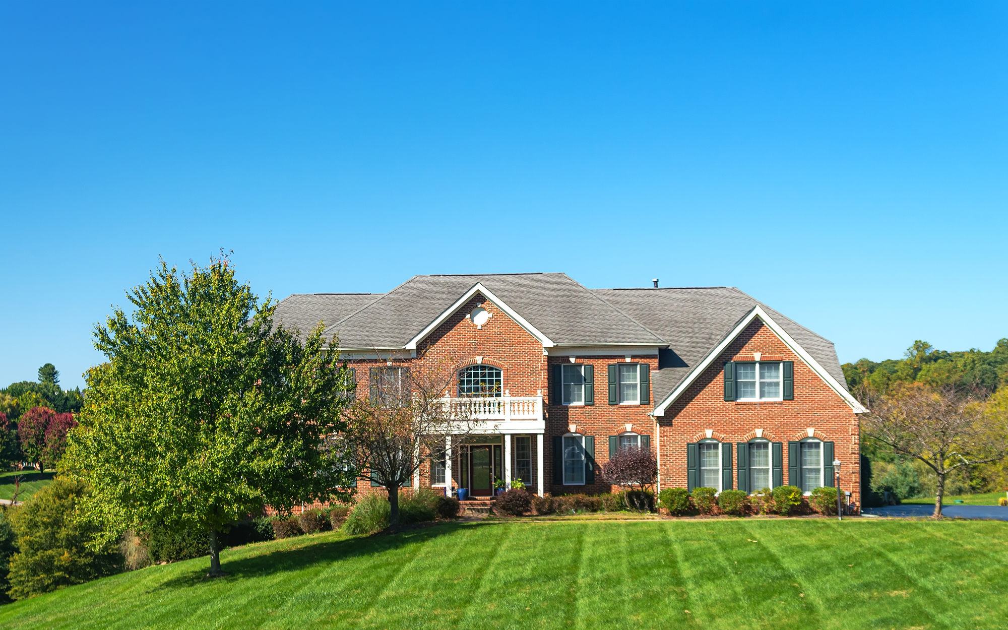 Large brick house with a large green lawn